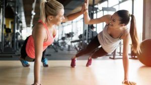 sportende vrouwen geven high five naar elkaar op de grond