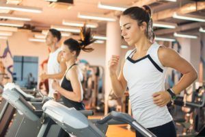 Sportende mannen en vrouwen rennen op de loopband in de sportschool