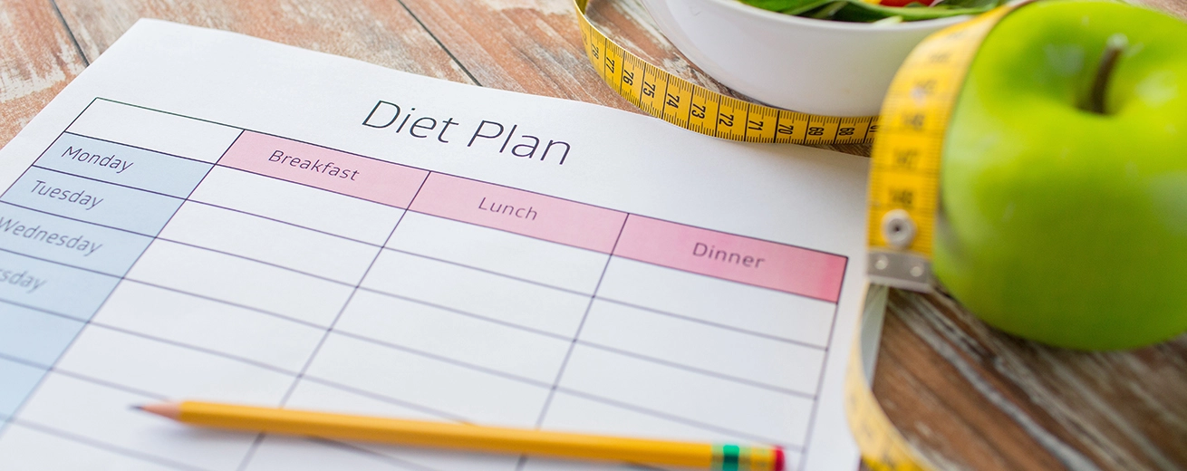Dieet Schema? Gratis eetschema om gezond en snel af te vallen Close-up van dieetplan en eten op tafel