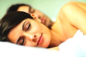 vrouw ligt vredig met man in bed te slapen