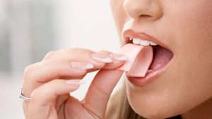 Jonge vrouw eet een kauwgom