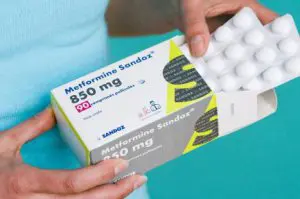 vrouw houdt metformine sandox doosje vast