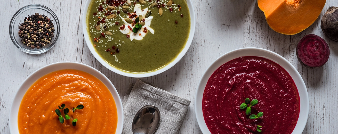 4 Voordelen en 4 Nadelen van het Soepdieet + Recepten Verschillende veganistisch eten. Kleurrijke groenten crème soepen en ingrediënten voor soep.